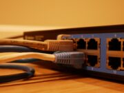 Close-up of a networking switch with multiple Ethernet cables plugged into its ports.